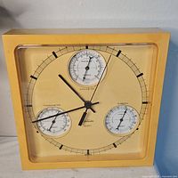 Front view showing clock face and three gauges