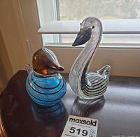 Both glass bird figurines on table