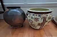 Overall view of both ceramic pots placed side by side on floor