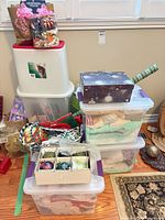 stacked plastic totes with gift boxes, bags and wrapping supplies
