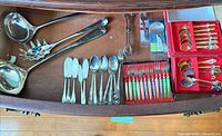 Drawer overview showing all flatware pieces, cocktail forks in red case, souvenir spoons in red case