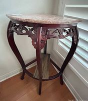 Full view of corner table showing marble top and carved legs
