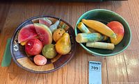 Two bowls with assorted carved stone fruit and vegetables