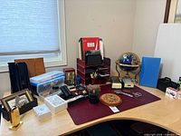 Overall view of desk accessories including globe, wooden clock, organizer, stapler, bins and more