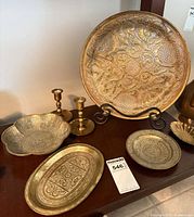 Large round engraved plate, smaller plates, pair of candlesticks