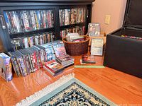 Entertainment cabinet filled with DVDs, basket of discs, ottoman open at right