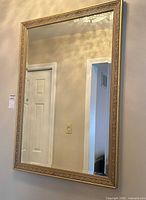 Full view of gold ornate framed mirror hung on wall