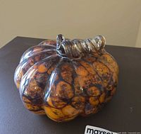 Top and side view of amber mottled glass gourd with clear curled stem