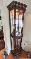 Full front view of wood framed glass curio cabinet