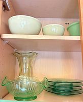 Upper shelf mixing bowls, lower shelf plates and vase