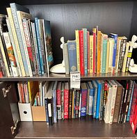 Two shelves filled with assorted hardcover and paperback books