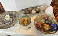 Overall lot view showing charger with candle, square glass dish, boat tray with mosaic balls, feather bowl with glass balls, ceramic pinecone