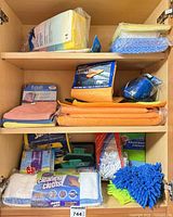Cabinet shelves showing full assortment of packaged and loose cleaning cloths