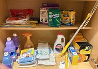 Full cabinet view showing all cleaning supplies on two shelves