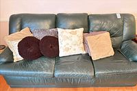 full view of green leather sofa with six cushions