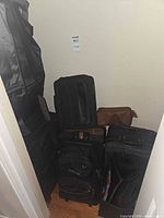 Group of multiple luggage pieces stacked in closet
