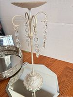 Metal candle holder on octagonal mirror tray; round pierced metal mirror tray visible