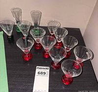Group of Smirnoff red-base and Tanqueray shot glasses on tabletop