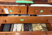 Drawer unit with four drawers filled with assorted folded linens in various colours and patterns