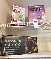 Retail boxes on shelf: Sunbeam Renue heating pad, DR-HO'S Neck Comforter, Woboru Massager