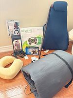 Group shot of all items showing circulation booster, neck massager, back support cushion, walking cane, traction slip-ons, massage mat and neck pillow