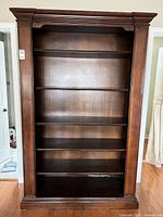 Full front view of wooden bookcase, shelves visible