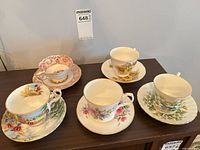 Five tea cup and saucer sets displayed on table