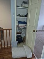 Closet shelves with folded bedding and towels