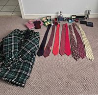 Group shot of shirt, ties and assorted small accessories laid out on carpet