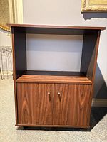 Front view of microwave stand showing open shelf and cabinet doors