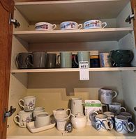 Cupboard showing all mugs and teaware on three shelves