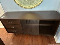 Front view of sideboard showing drawers, glass doors and legs