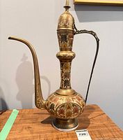 Full view of brass ewer pitcher showing height, spout, handle and etched decoration
