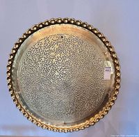 Full view of brass tray showing entire design and scalloped rim