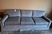 front view of grey three-seat sofa