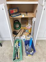 cabinet with fish tape, parking mat bag, jack, trays of tools