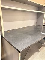 Desk work surface showing three grommet holes and hutch shelf