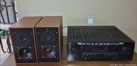 Denon receiver beside two ProAc speakers on table