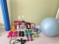 Overall lot showing foam roller, DVDs, bands, dumbbells, stability ball