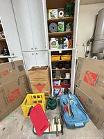 Overall lot inside garage cabinets showing tools, chemicals and pots