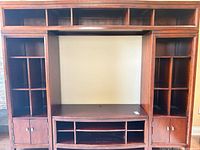 Full frontal view of wooden entertainment centre showing all sections