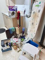 Group shot of all cleaning items including Bissell cleaner, Swiffer kit, ironing board and tools