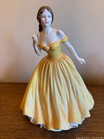 Front view of Royal Doulton "Elizabeth" figurine standing on wooden surface