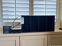 Clock radio, sealed media packs and CD storage shelf overall view