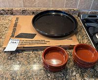 overview of boxed rectangular stone, black round dish, two ramekins