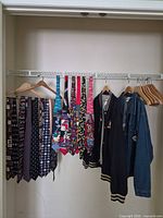 Overview of novelty ties, Disney bomber jacket and Pooh denim jacket on hangers