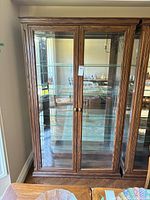 full front view of wooden curio cabinet with glass doors and shelves