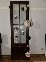 Full view of mahogany door with glass panes, knobs, and hanging items