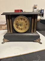 Full view wooden mantel clock with brass dial and gilt feet