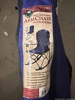 Product label on blue carrying bag showing deluxe folding arm chair with rockers